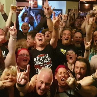 Shot from the band's perspective on stage, the rock crowd at the Pub, Lancaster, cheering and waving their arms. Guitarist Neil has also photo-bombed the picture!