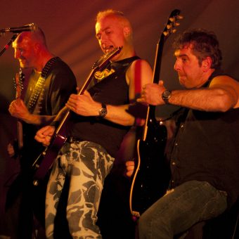 Richard, Neil and Alan playing their guitars and throwing shapes.